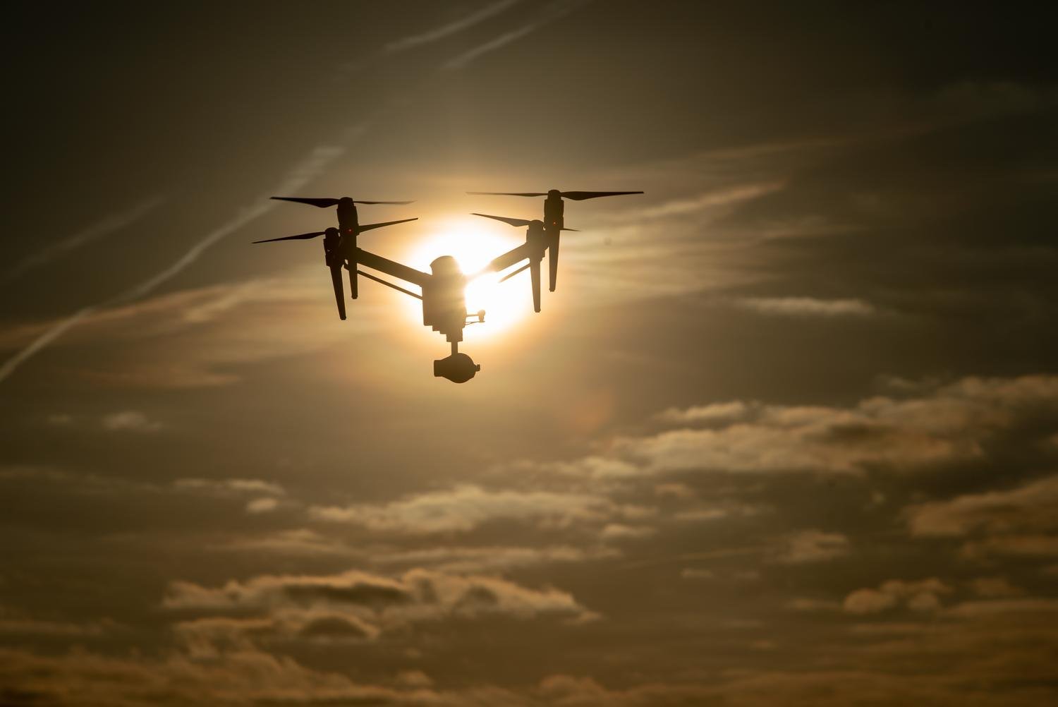 Drone en vol à contre-jour au coucher du soleil